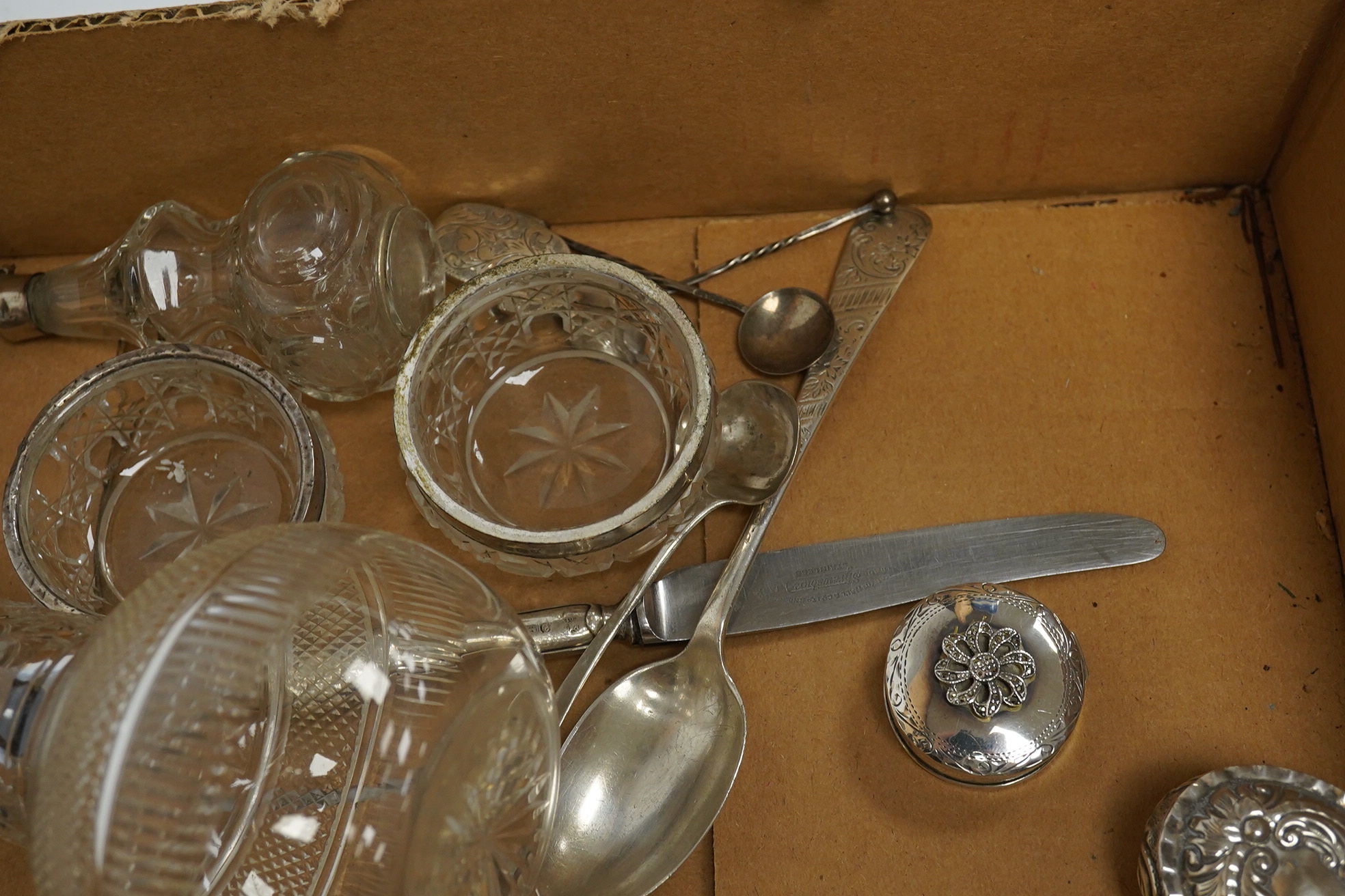 Five assorted silver topped toilet jars, a pair of silver mounted glass salts, a late Victorian repousse silver oval pill box, two modern silver pill boxes, four silver spoons, a silver handled knife, a pair of silver ha